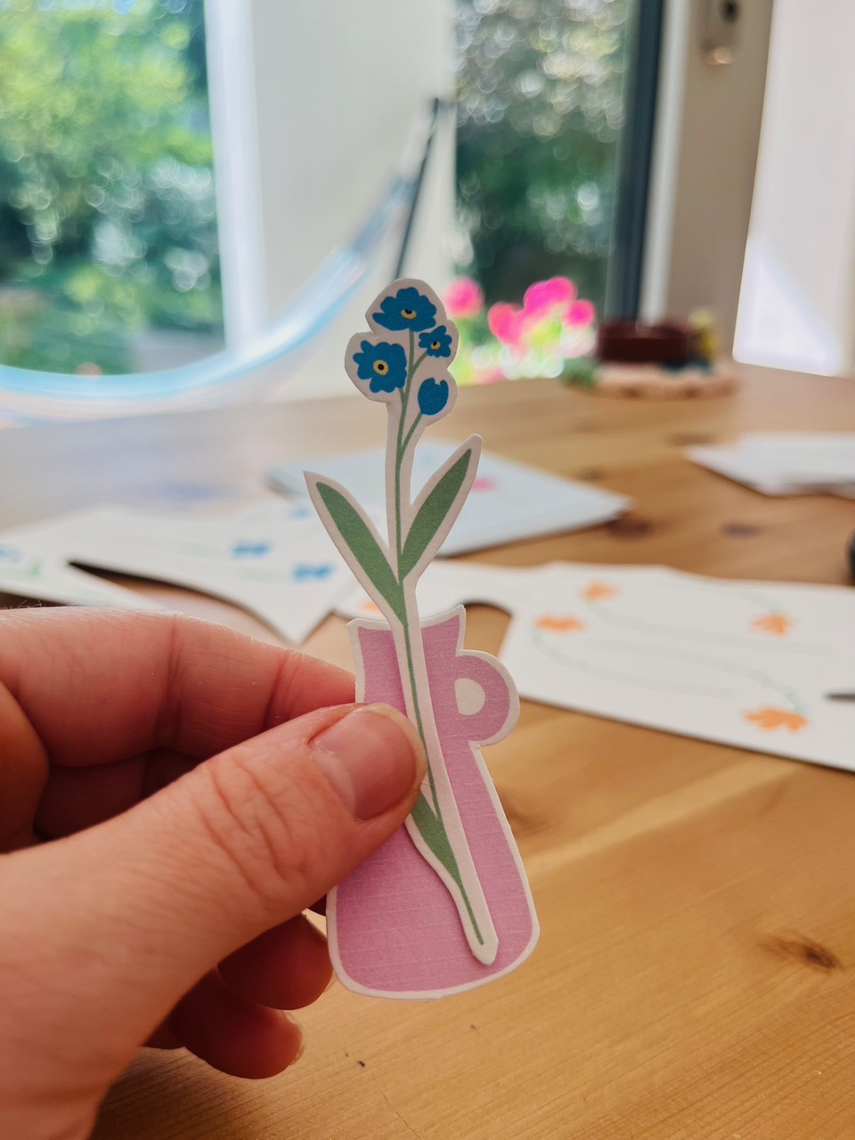 D'chlini Poscht &mdash; sticker de flores sostenido en la mano